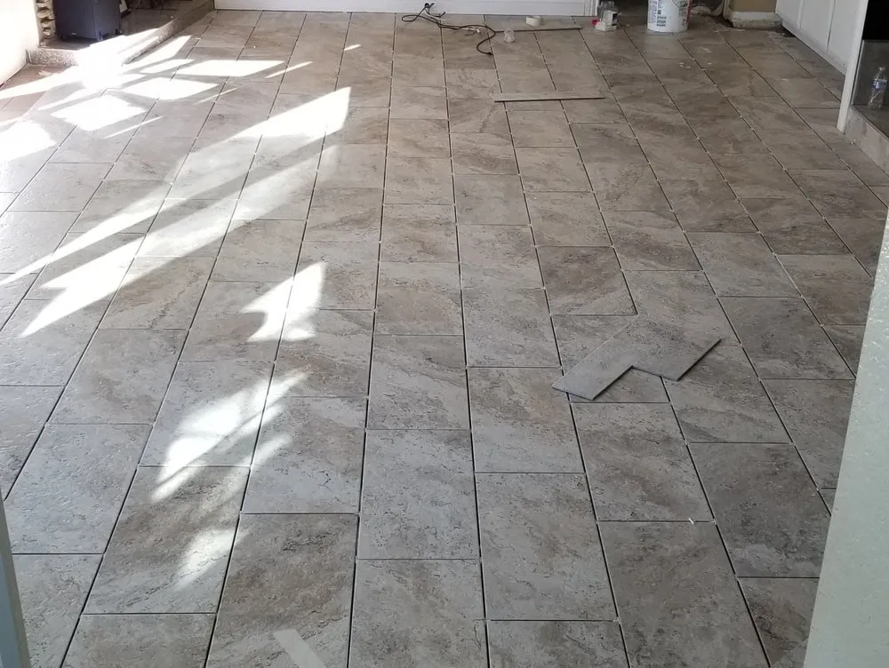 Travertine-look tile flooring partway through installation.